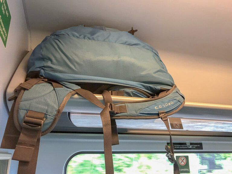 Overhead train rack with travel bag stored