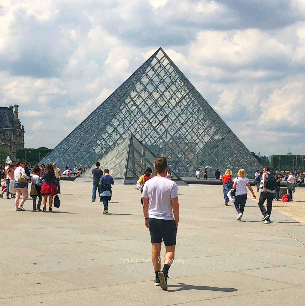 Mark walking in front of the Louvre