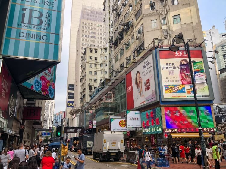 street signs and people walking in Causeway Bay