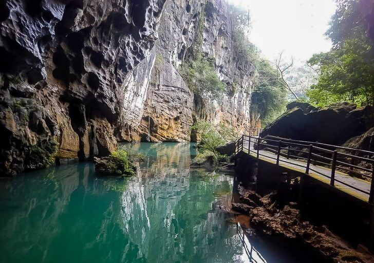 inside Phong Nha dark cave looking back out with boardwalk