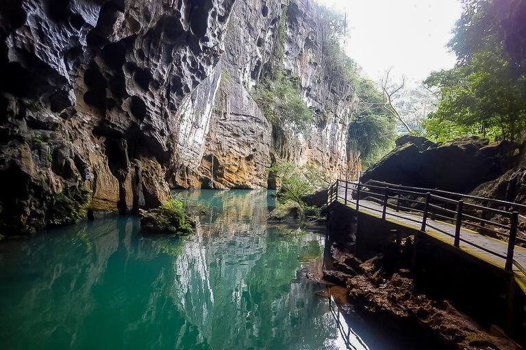 inside Phong Nha dark cave looking back out with boardwalk