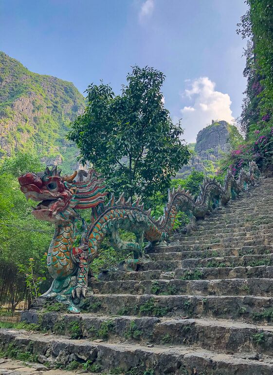 Colorful dragon at start of stone staircase to viewpoint Mua Cave