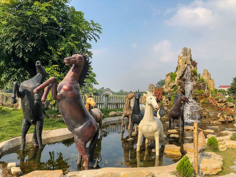 Wooden horses on display in water feature Ninh Binh