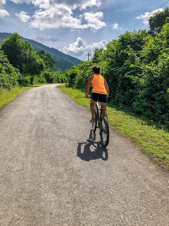 Woman cycling along a quiet road in Vietnam