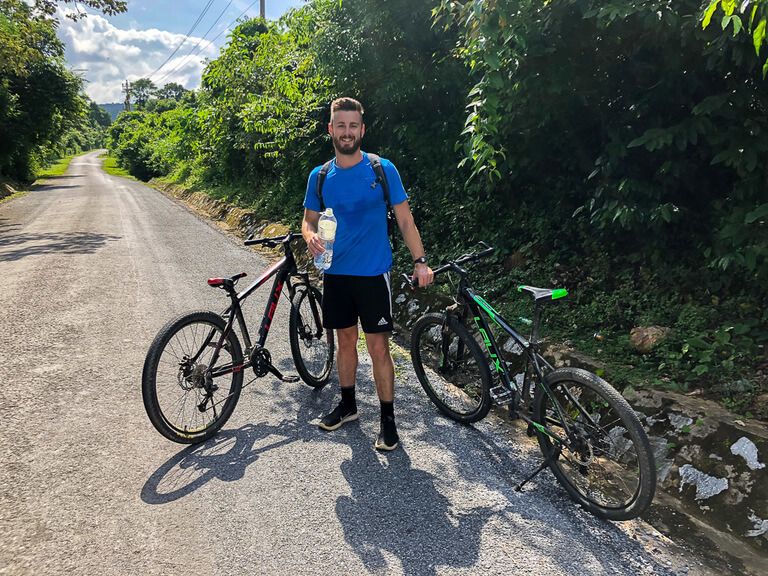 Man stopping in the middle of the road with two mountain bikes in vietnam