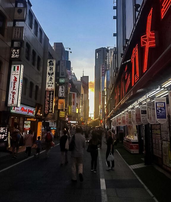 Tokyo street at sunset with lights on buildings