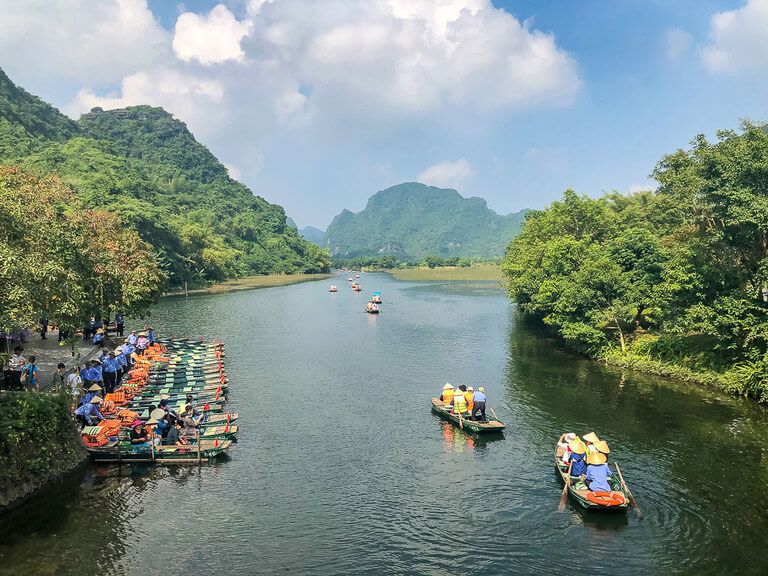 wooden boats leaving dock heading upriver