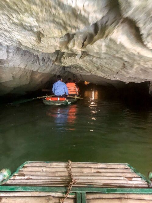 A boat entering a cave with another boat ahead in line