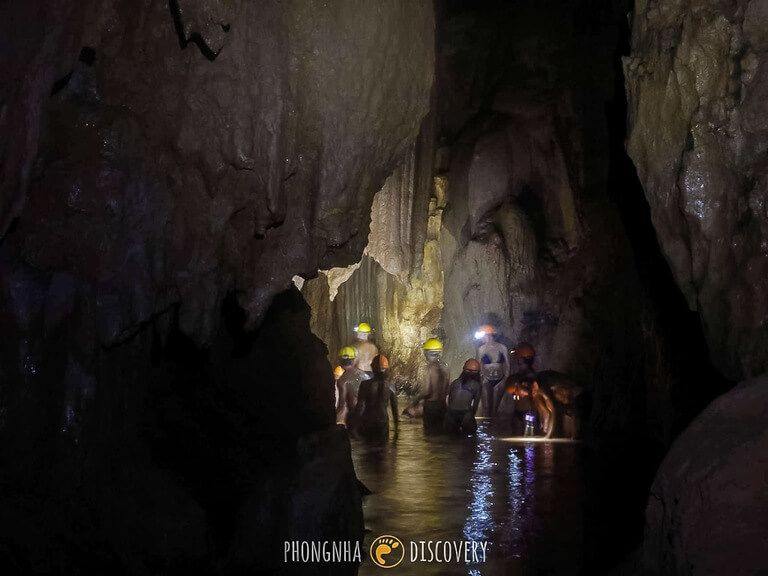 mud chamber inside dark cave Phong Nha dark and head torches on