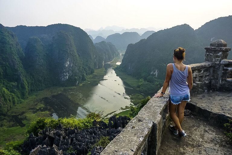 Kristen stood leaning against stone wall overlooking viewpoint on Ninh Binh itinerary