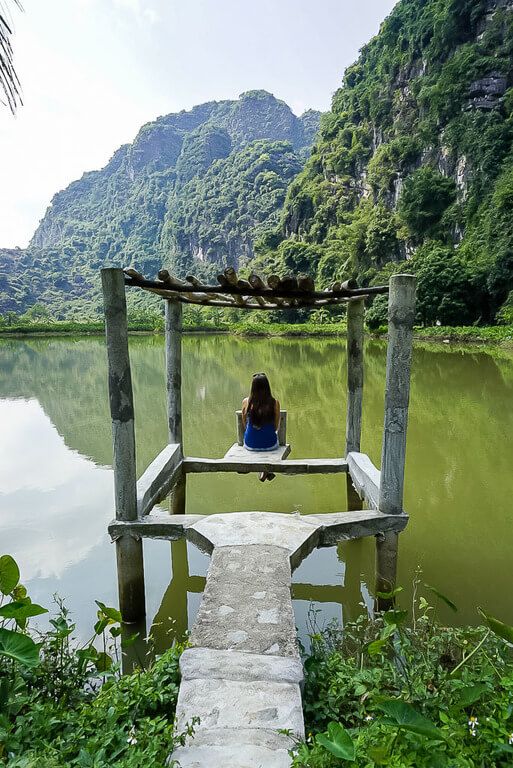 Kristen sat on a square shaped wooden dock overlooking a lake