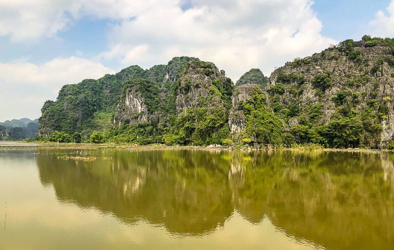 Views of limestone rocks and a green lake near Tam Coc