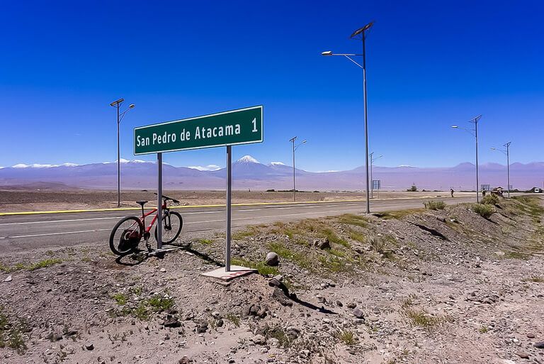 mountain bike propped up against road sign near valle de la luna