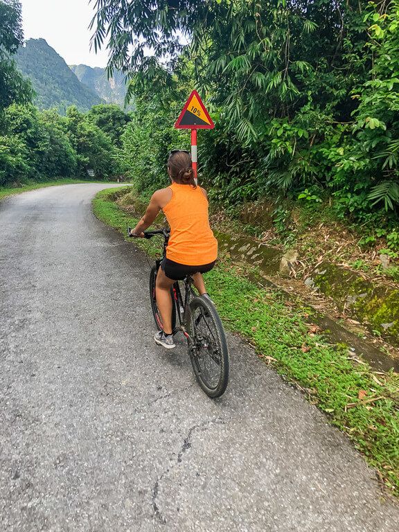 Woman cycling down a steep hill 10% gradient