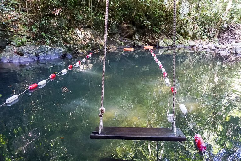 An empty swing in front of swimming hole botanic gardens Phong Nha