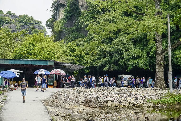 Tour group from bus entering Bich Dong pagoda in Tam Coc