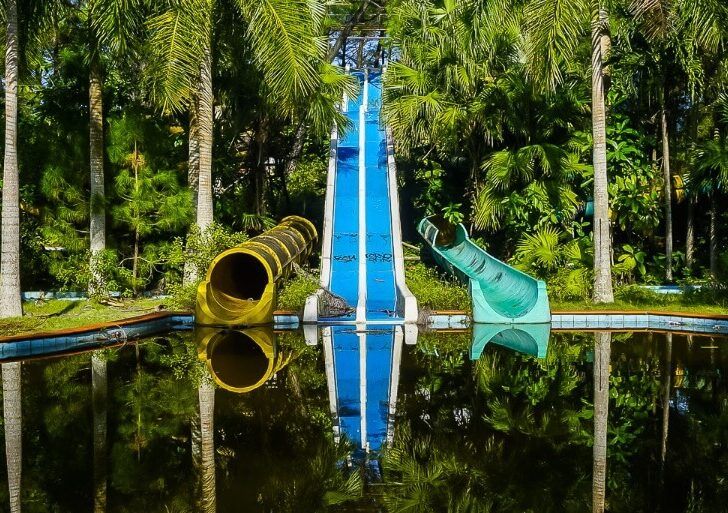 Abandoned water park hue Colorful water slides reflecting in pool below