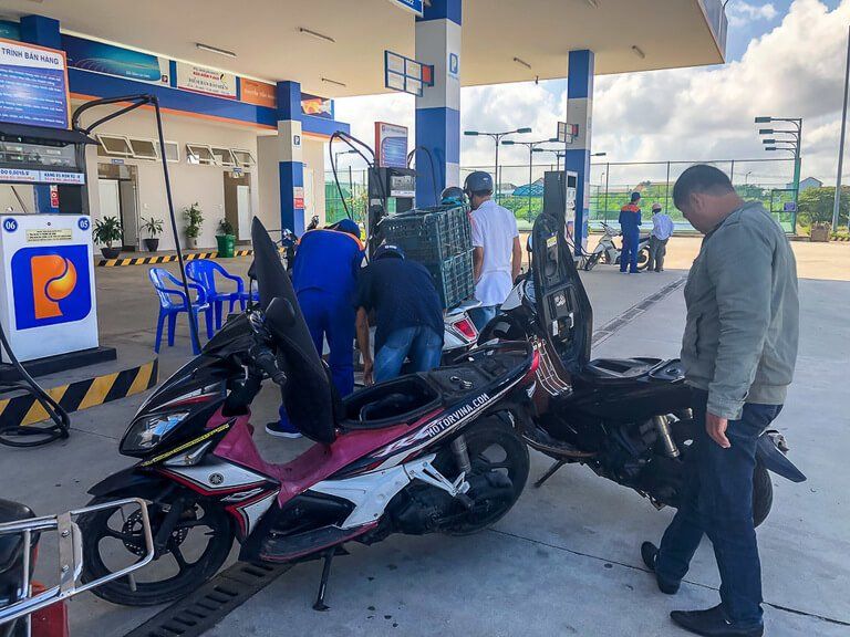 Motorbike guide fueling our motorbikes in a gas station near hue