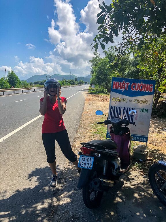 Kristen side of main road with helmet on next to motorbike between da nang and Hoi An