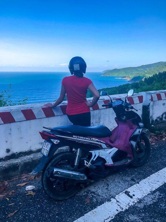 Kristen enjoying the view from Hai Van Pass with motorbike parked