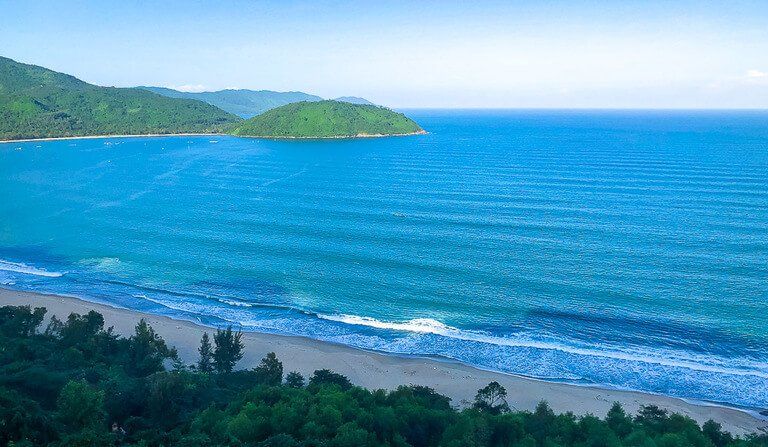 Da Nang Bay blue sea and beach with green trees