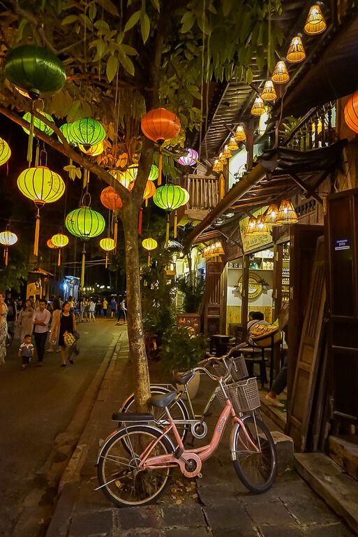 Hoi An old town at night lanterns and a bike propped against a tree vietnam