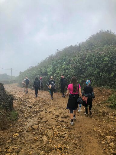 Kristen hiking along a dirt track in clouds sapa