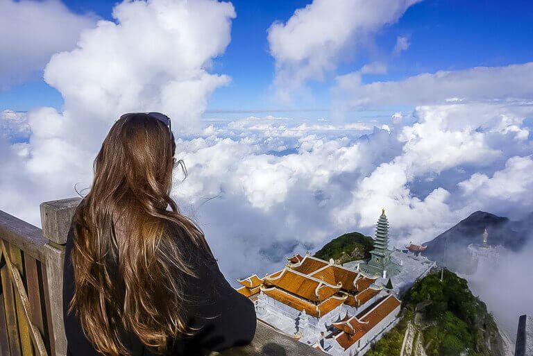 Kristen looking at temple above clouds at the Fansipan summit