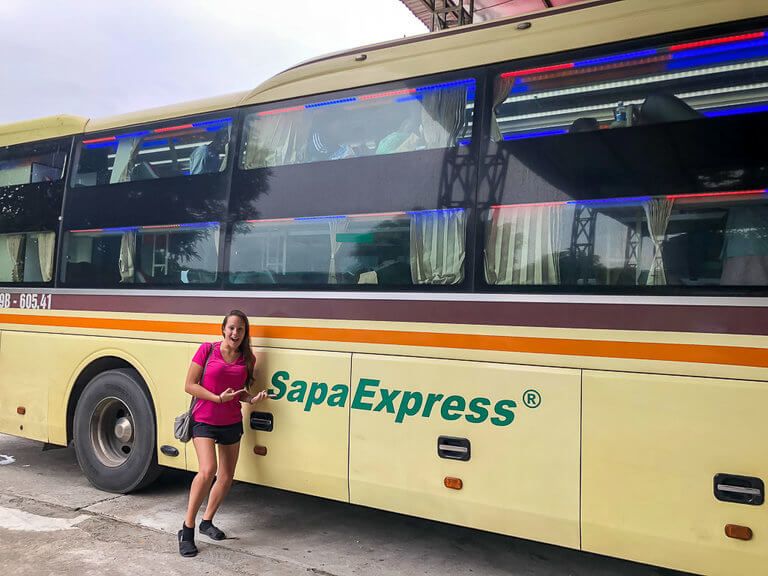 Kristen pointing to Sapa Express logo on sleeper bus Vietnam