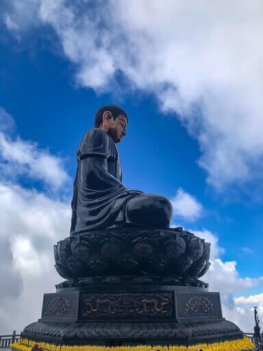 Statue of a huge black buddha on Fansipan mountain as part of sapa itinerary in northern vietnam