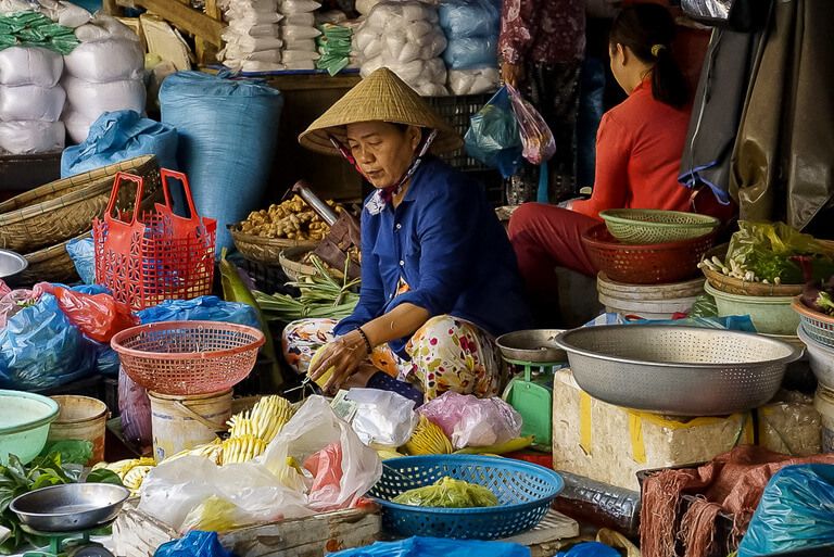 Local women working at Hoi An Central Market peeling vegetables