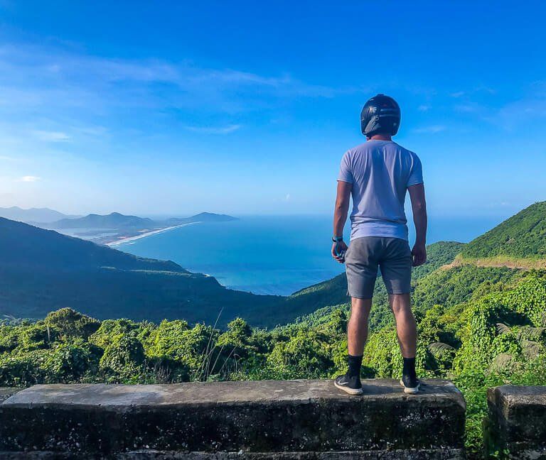 Mark with motorbike helmet on overlooking bay from top of hai van pass between hue and da nang Vietnam