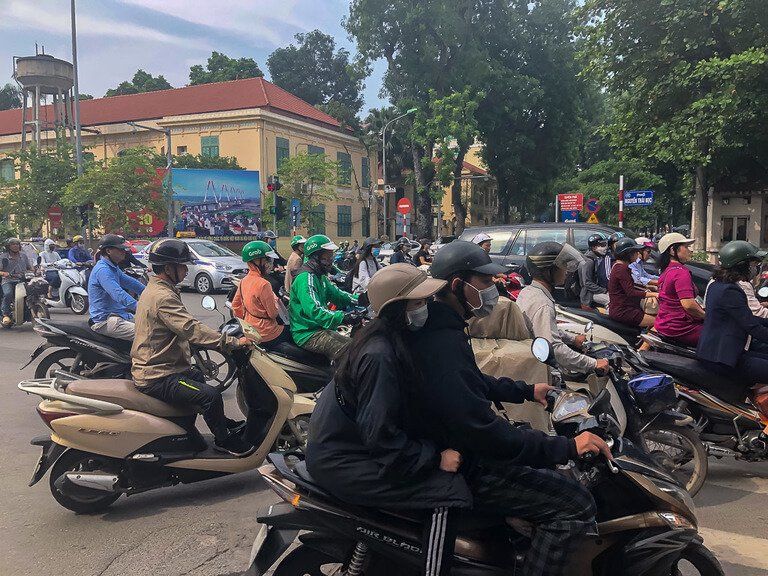 Manic traffic in Hanoi Vietnam dozens of scooters in a huddle