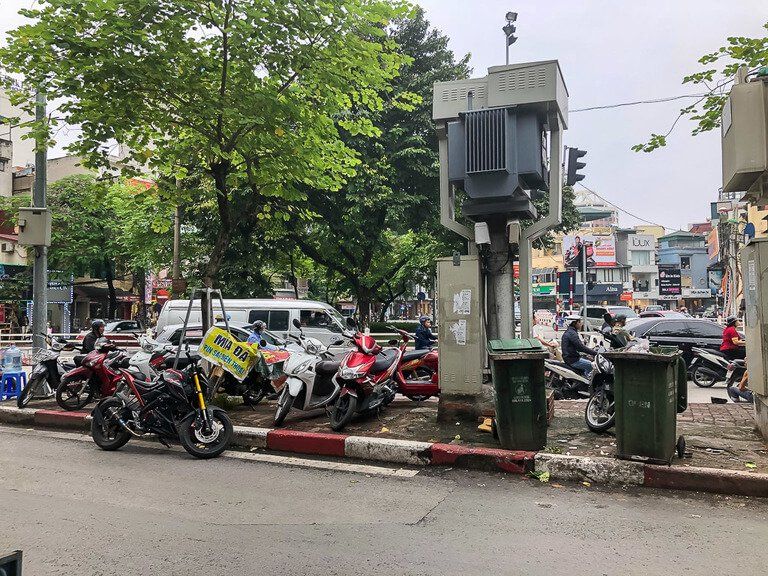 trash cans and motorbikes parked in between roads