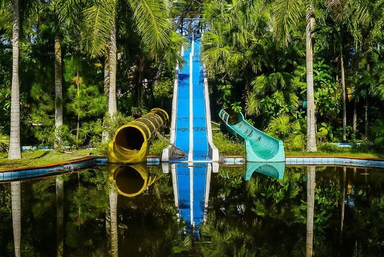 Water slides reflecting in water abandoned water park hue sixth stop on 3 week Vietnam Itinerary
