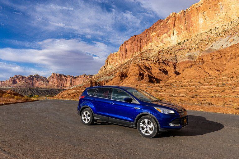 Our blue ford against orange rocks at Capitol Reef Utah