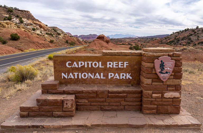 Capitol Reef entrance sign made of bricks with road to left