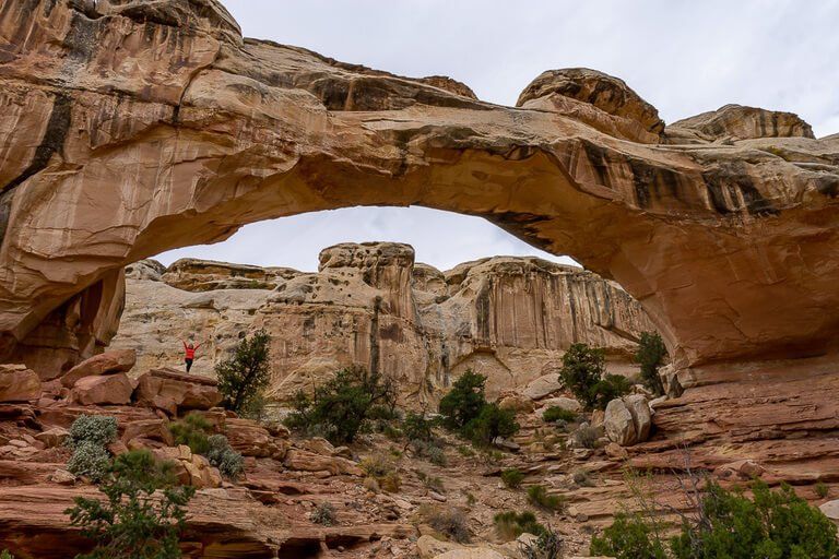 Kristen stood underneath Hickman Bridge natural rock formation in Utah