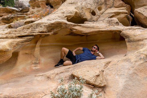 Mark messing around in a pretend pose inside cool rock formations at Capitol Reef