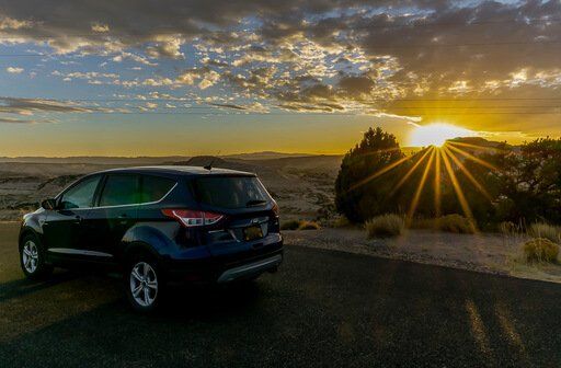 our car at sunset with sunburst near Capitol Reef highway 12