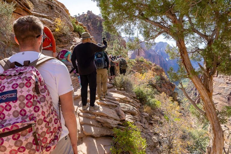 Mark at Angels landing narrow ledge and path with many other people on the trail