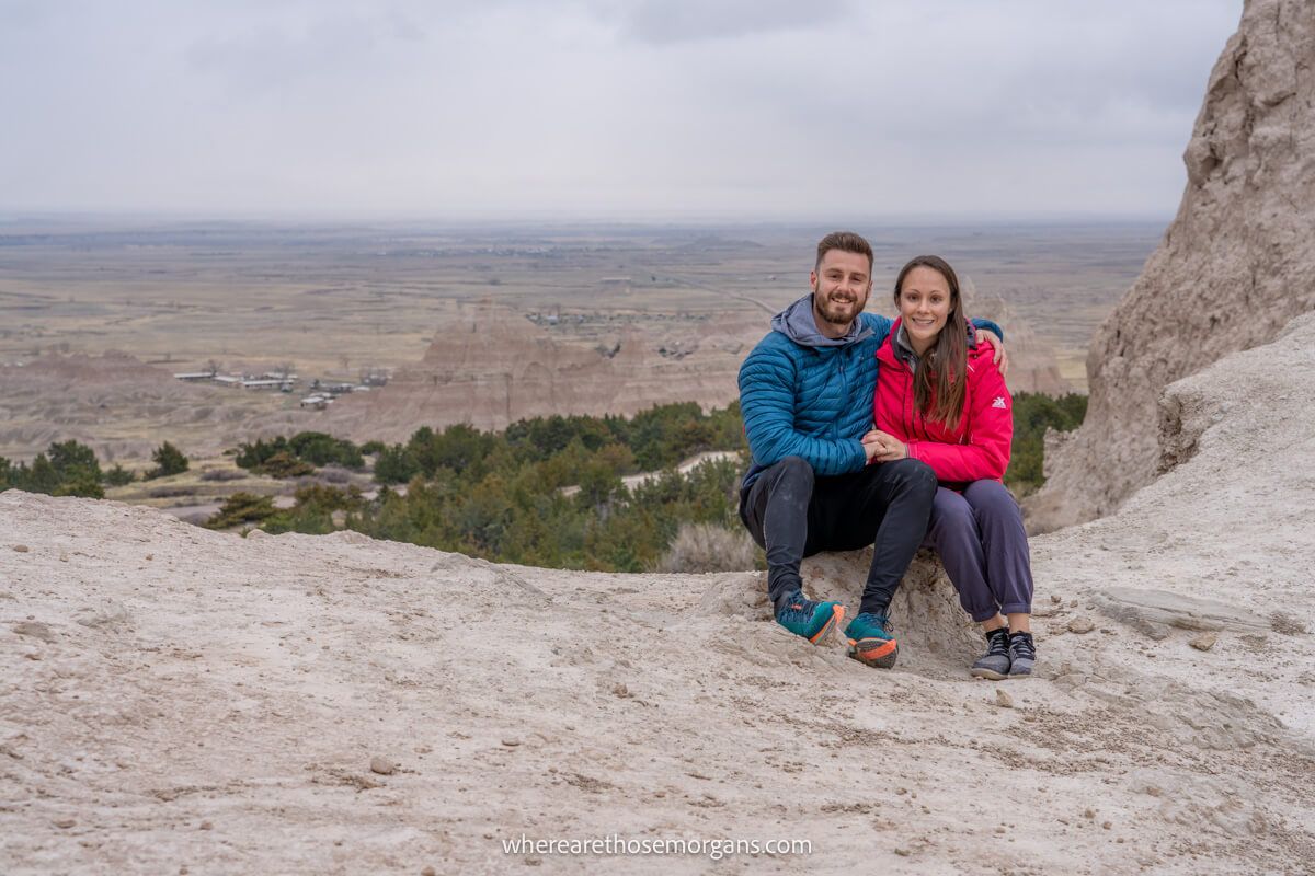 Mark and Kristen Morgan from Where Are Those Morgans sat together on rocks at the end of Notch trail hike in Badlands National Park when driving a road trip through South Dakota