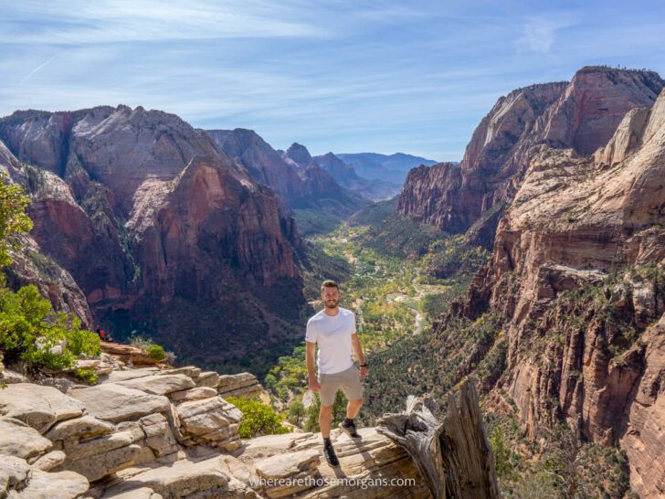 Tips for beginner hikers to use in situations like this photo of a man standing at the summit of dangerous hike Angels Landing in Zion National Park