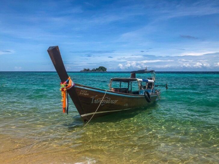 Long tail boat on clear turquoise water on Koh Lipe Itinerary Thailand