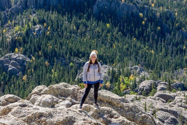 Kristen at the summit of Black Elk Peak South Dakota with a beanie hat on for warmth
