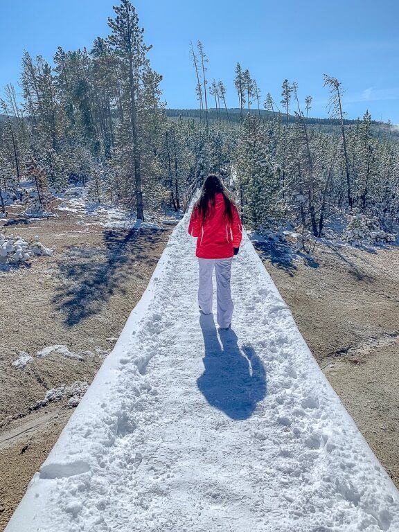 Kristen walking on snowy boardwalk Norris Geyser Basin Yellowstone