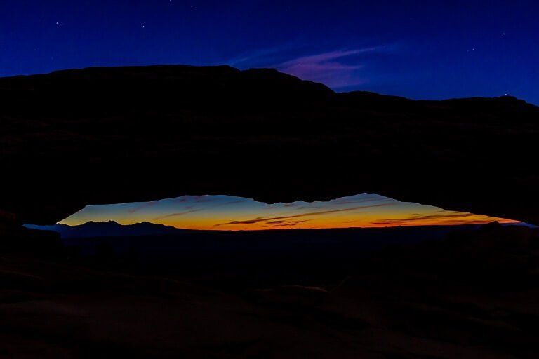 Mesa Arch before twilight deep purples and silhouetted rock formation