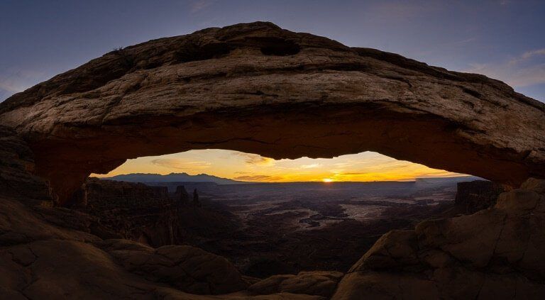 Sun beginning to rise behind rock formations in Utah