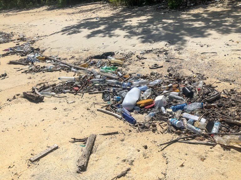 Loads of trash along a narrow beach on a secluded Thai island