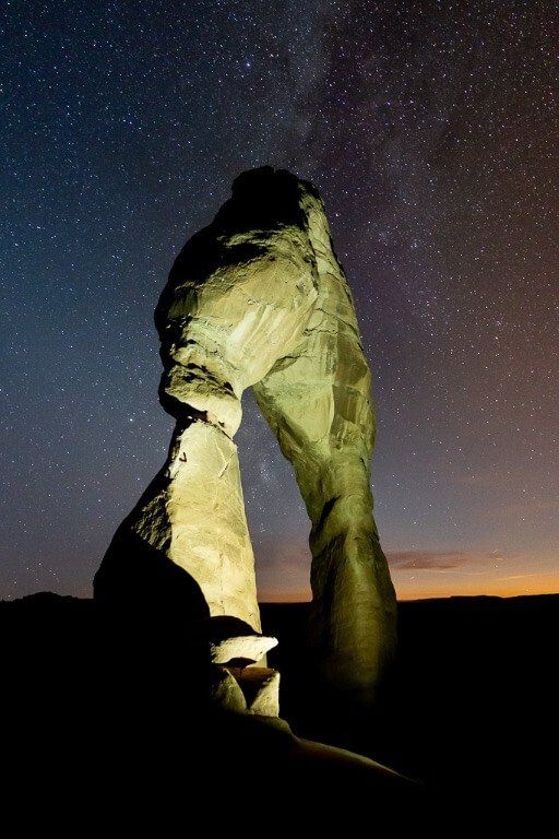Enormous natural sandstone arch formation lit up at night
